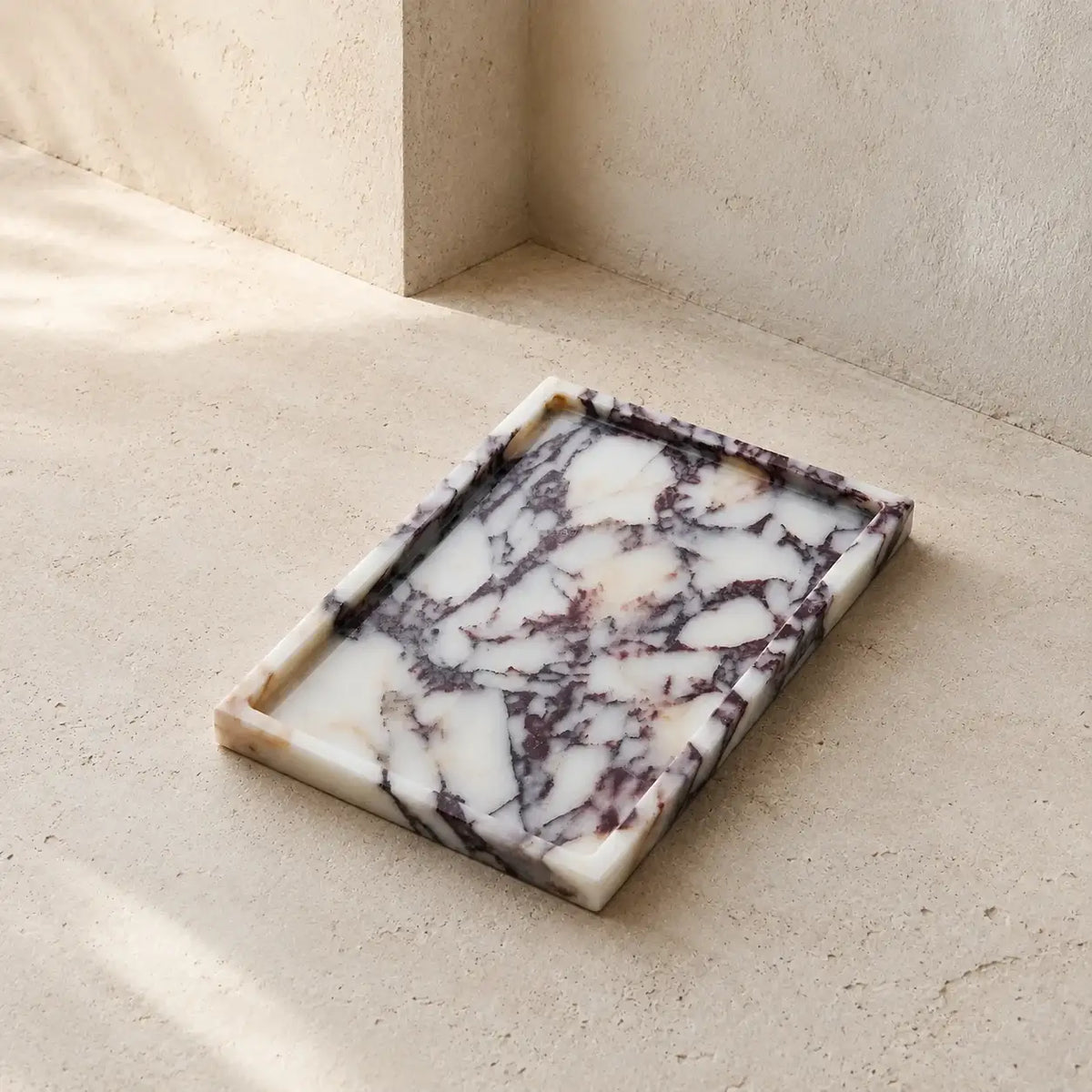 Rectangular Calacatta Viola marble tray with branching burgundy and grey veining on pale stone
