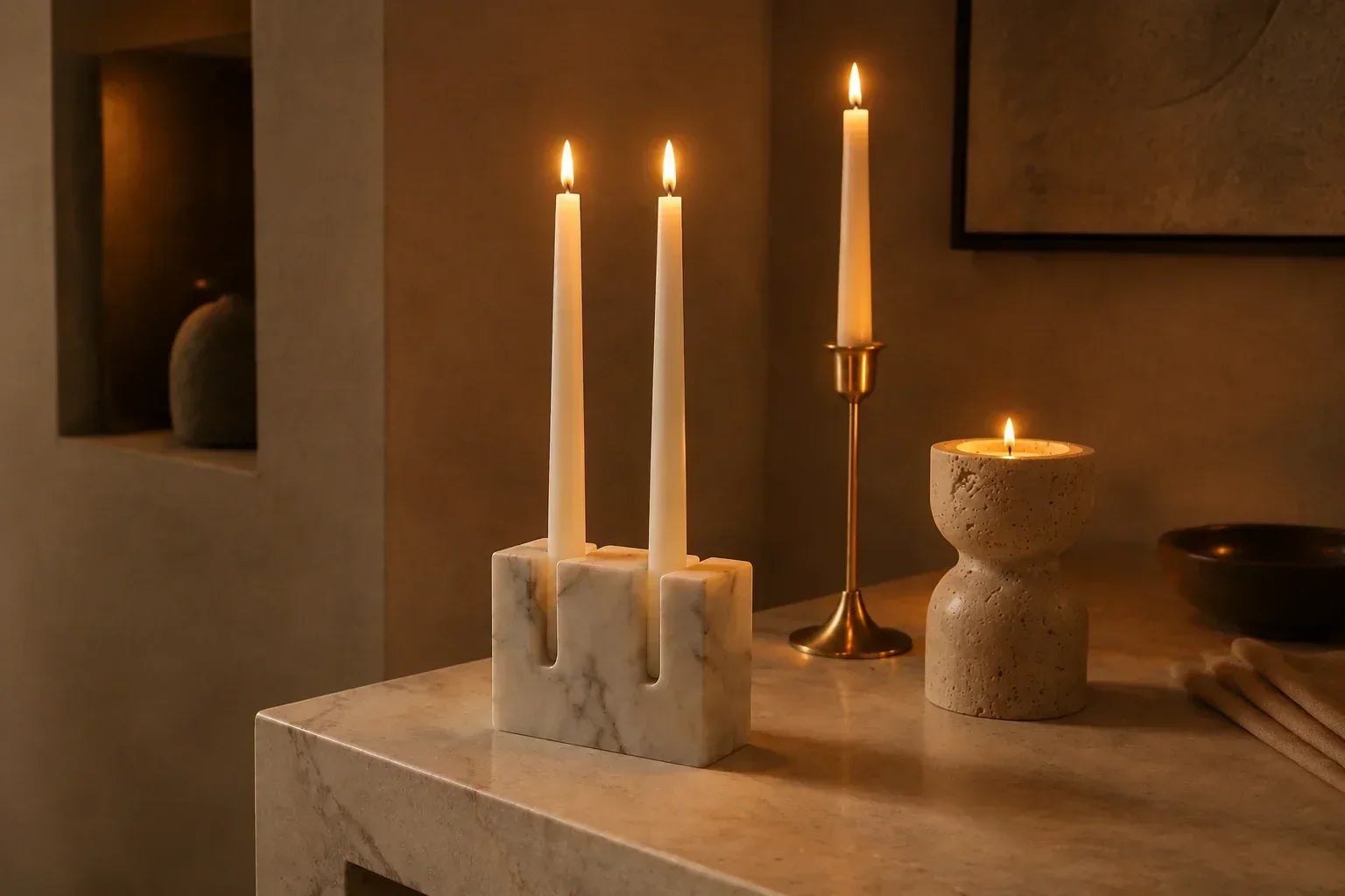 Natural stone and brass candle holders creating a warm evening atmosphere in a considered interior