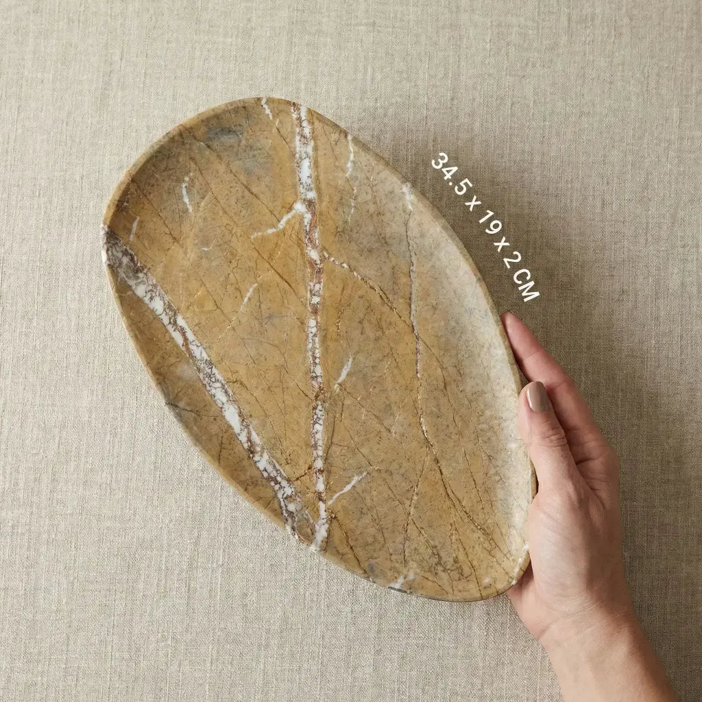 Hand holding Autumnal Plateau Stage gold marble tray for size reference and scale