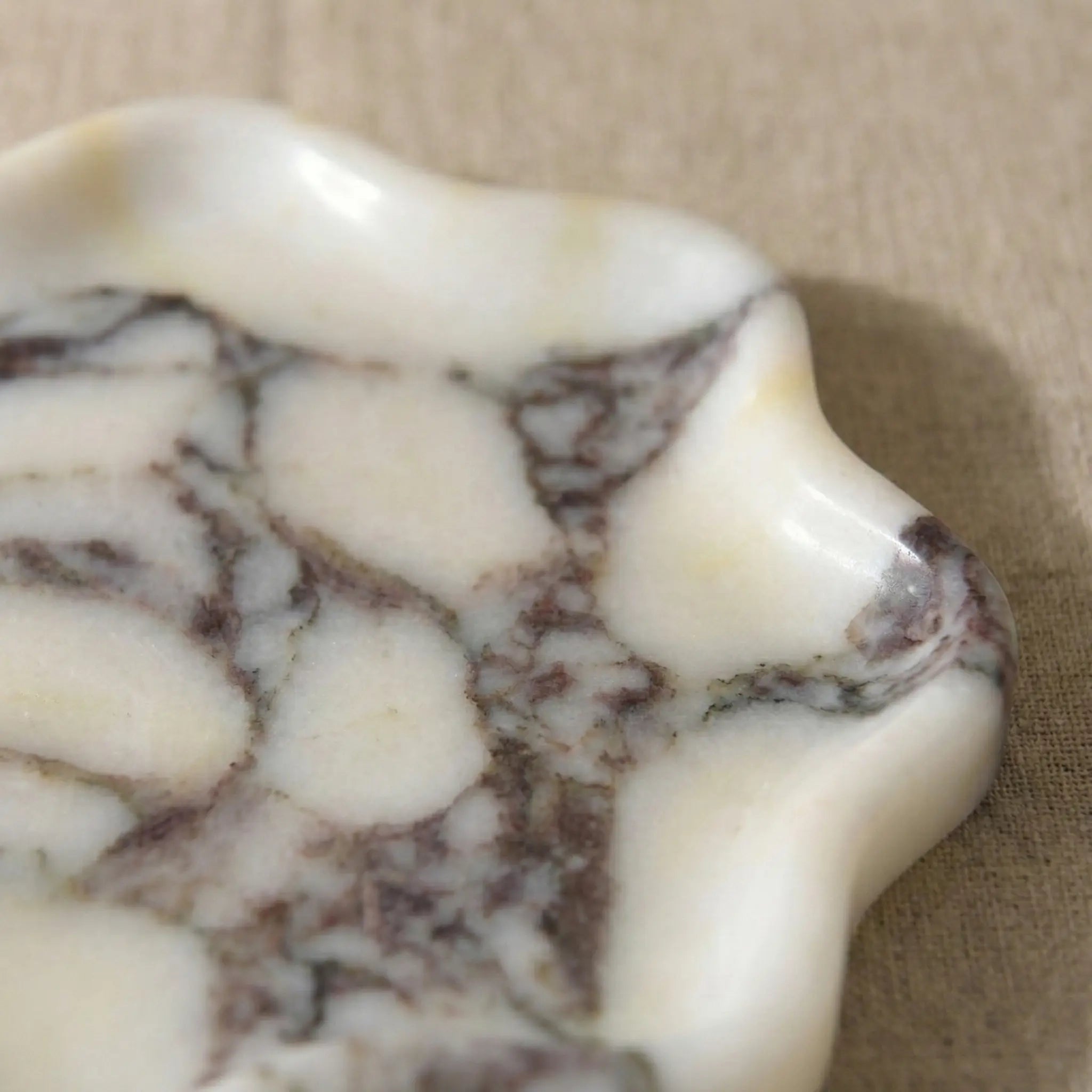 Detailed macro shot of Calacatta Viola marble showing rich purple mineral veining and texture