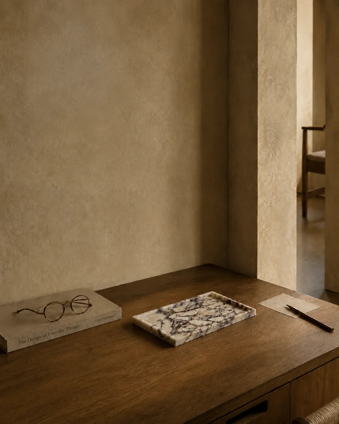Calacatta Viola marble tray styled on a warm wooden desk in a quiet editorial interior