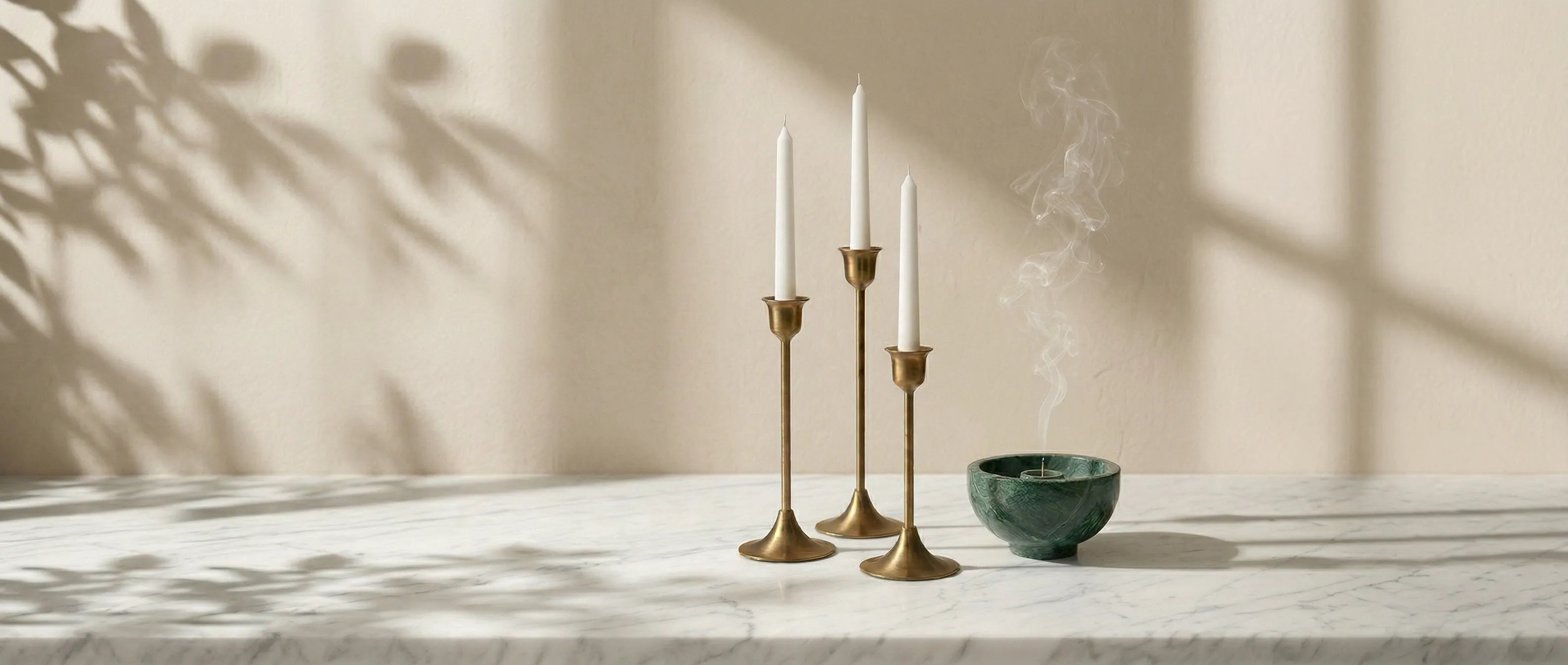 Desktop home slideshow displaying the elegant Brass Monolith Trio set on a white marble plinth with soft morning shadows.