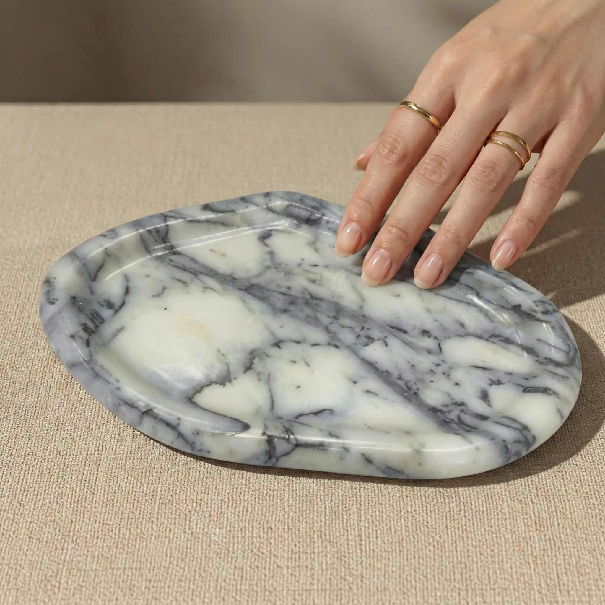 Hands resting on Irregular Marble Platter to show scale and smooth handcrafted stone surface