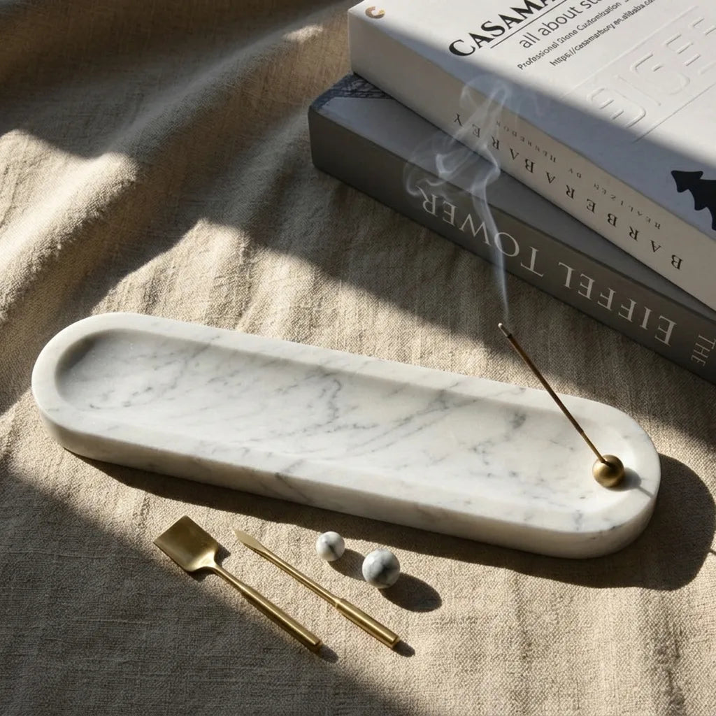 Close-up of Linear Monolith Relic marble stone showing smooth texture and brass incense holder