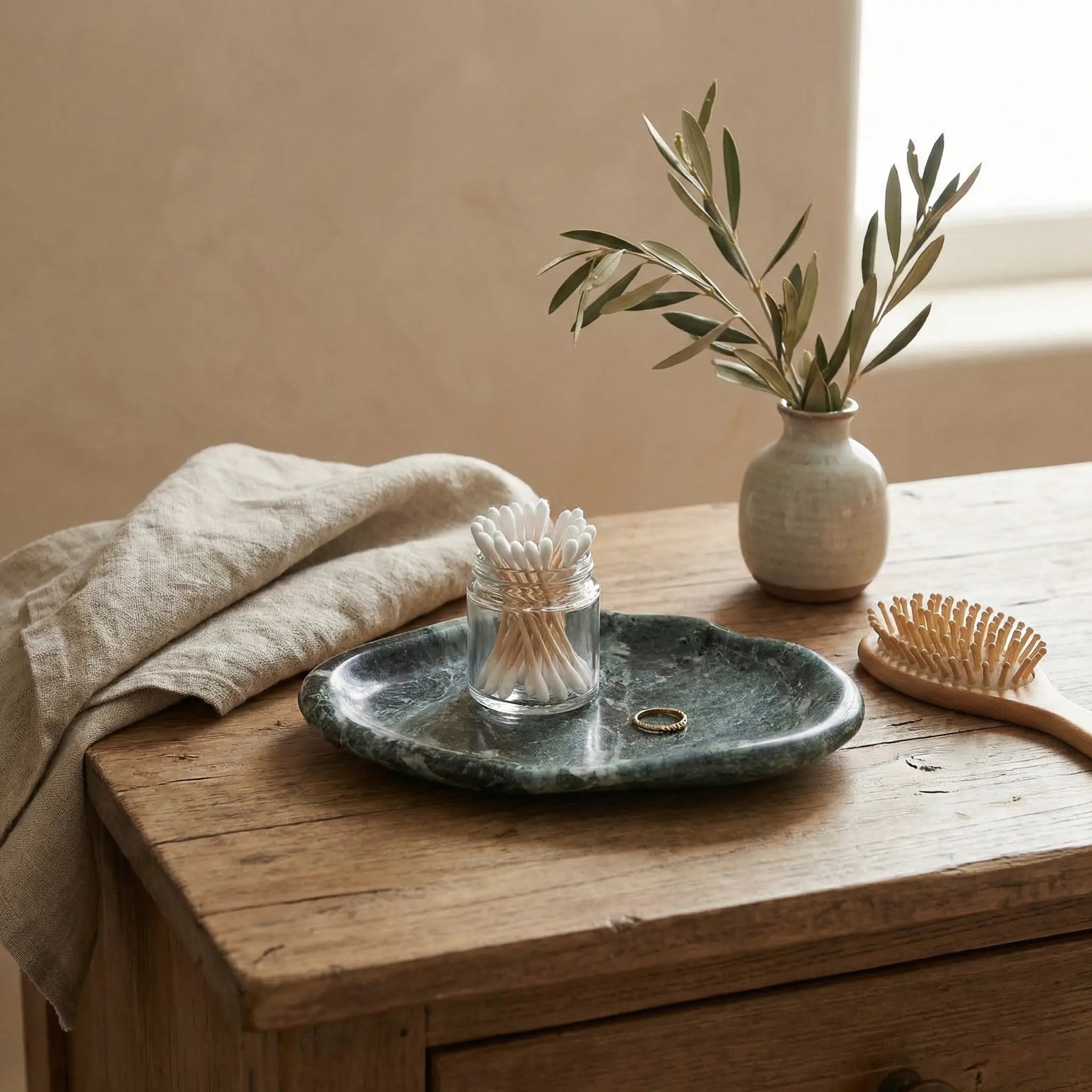 Marble Cloud Tray used as a luxury jewelry and accessory organizer on a rustic wooden table