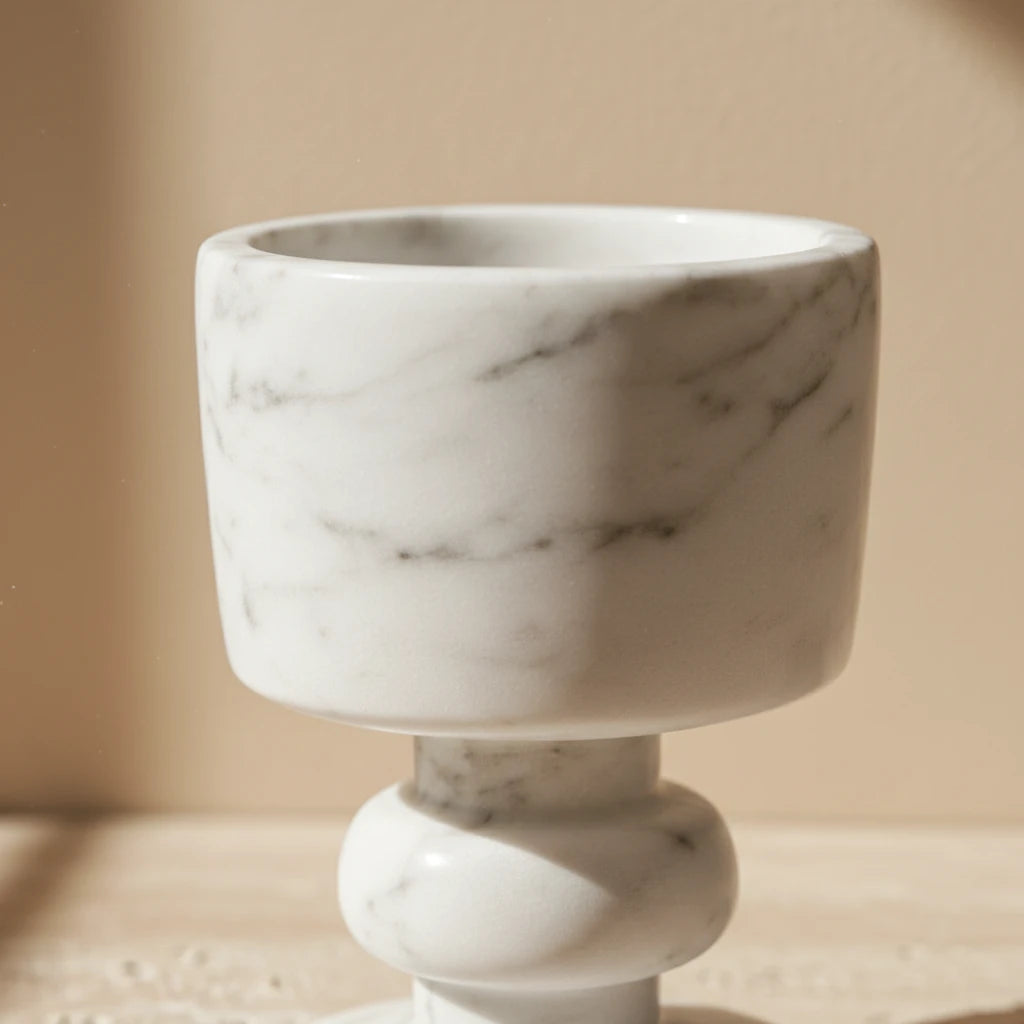 Low angle detail of Marble Goblet Holder highlighting the curved stone pedestal and veins
