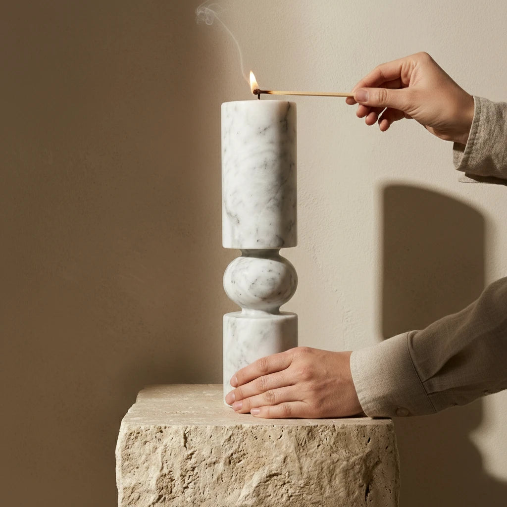 Hand lighting a taper candle in the Marble Pillar Holder sculptural stone pedestal
