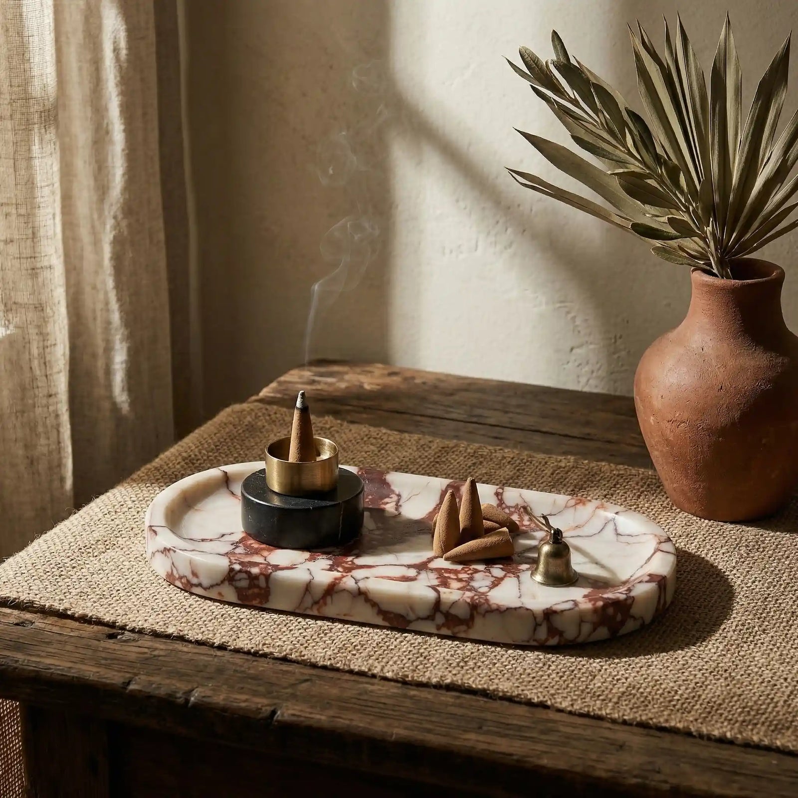 Sangria Plateau Stage red marble tray used as an incense holder in a cozy home decor setting with a ceramic vase.