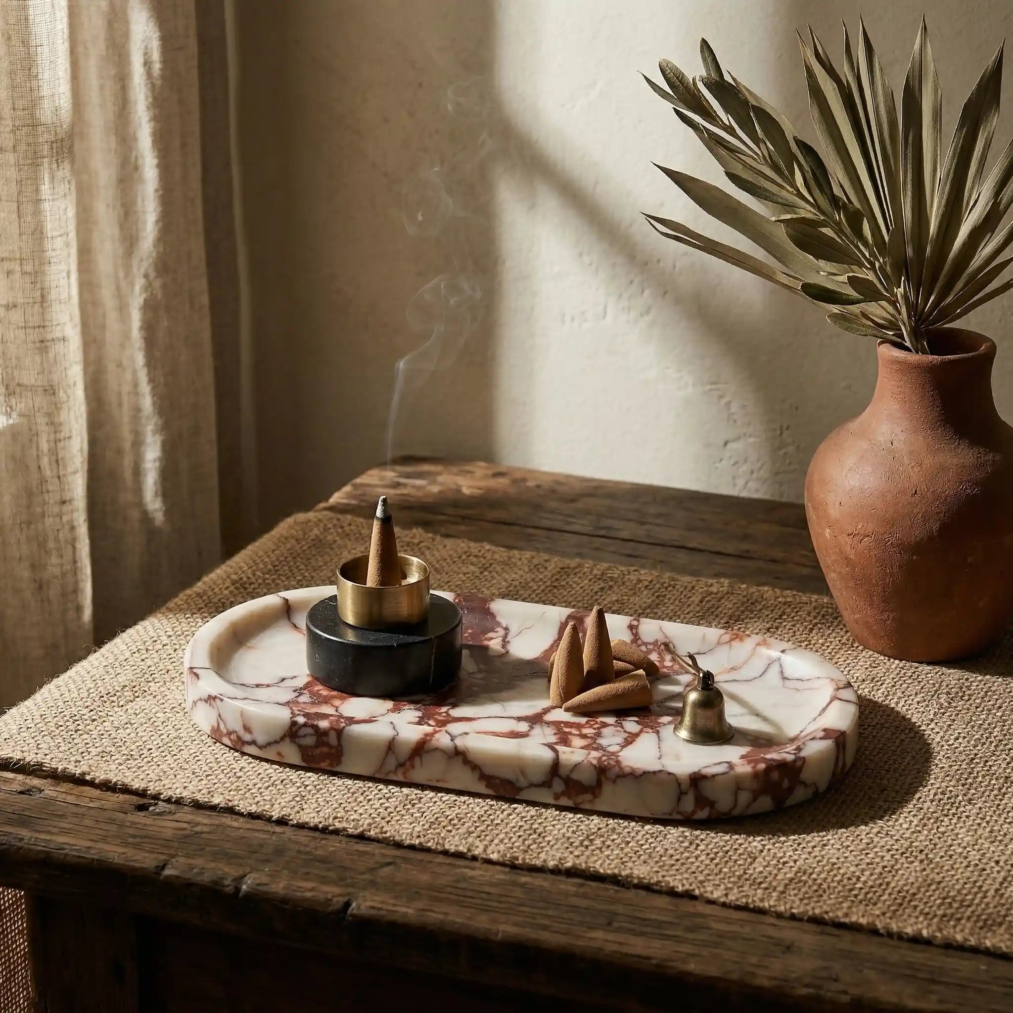 Sangria Plateau Stage red marble tray used as an incense holder in a cozy home decor setting with a ceramic vase.
