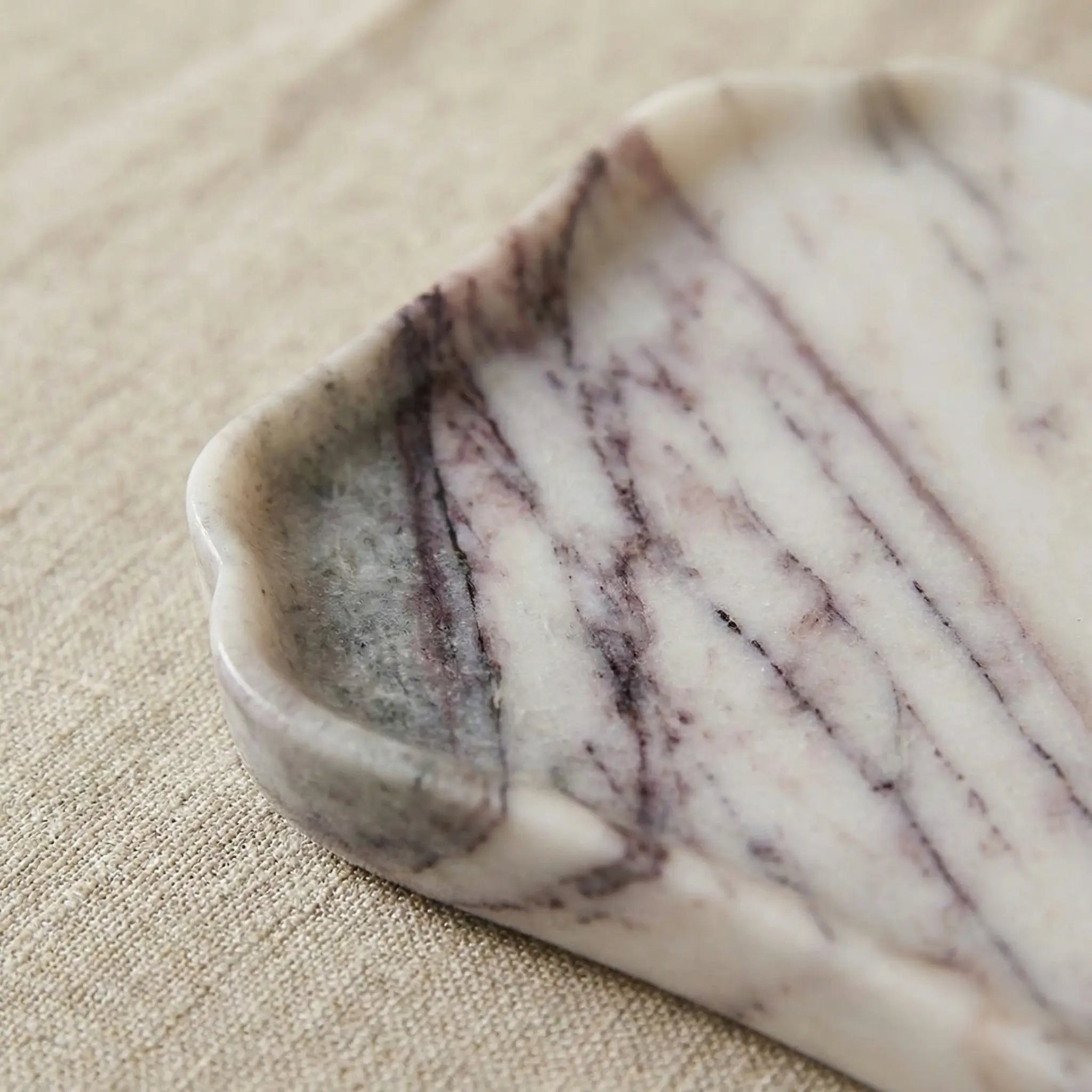 Detailed shot of the wavy scalloped edge on the 100% natural purple and white marble platter