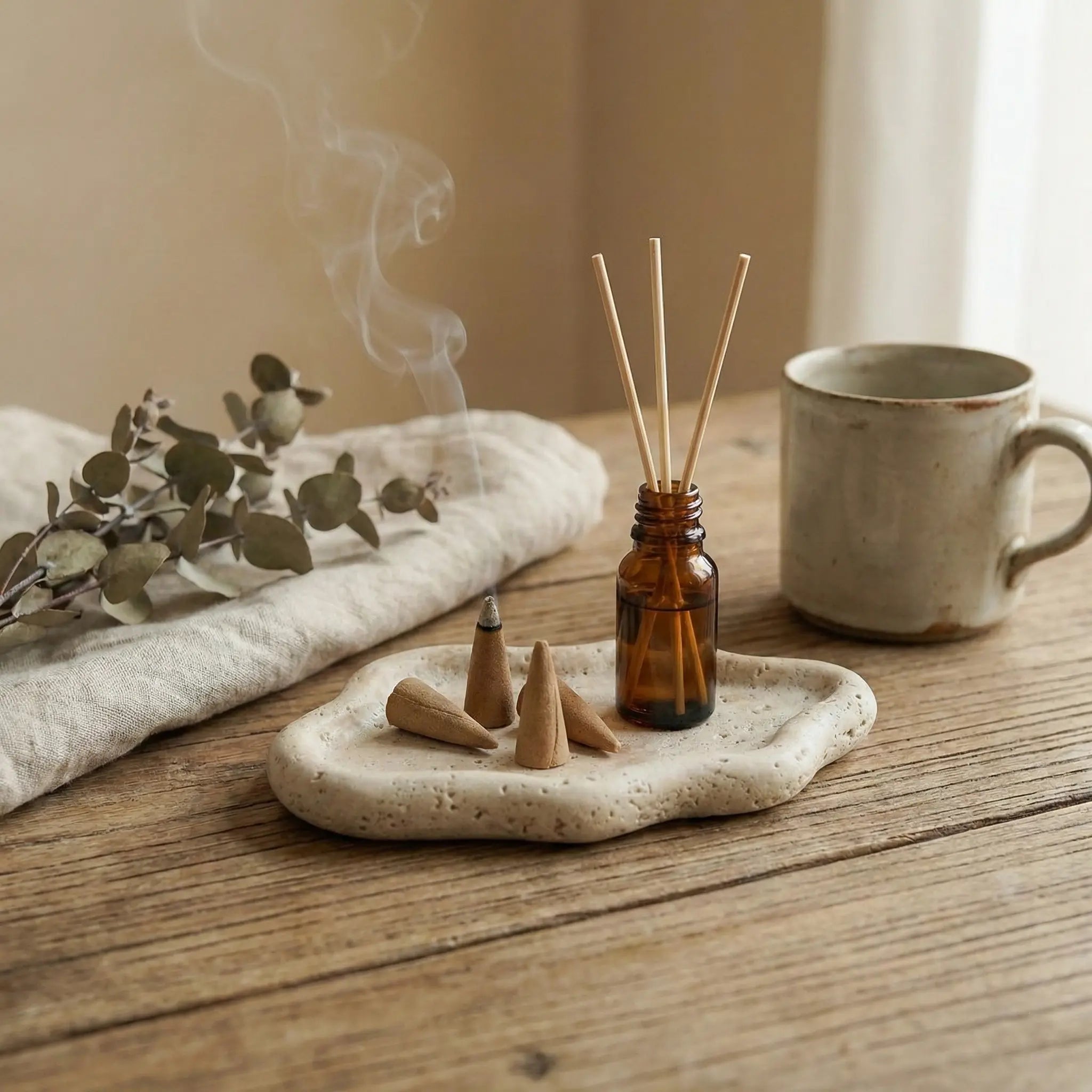 Travertine Cloud Tray used as a base for incense cones and diffusers in a cozy lifestyle setting