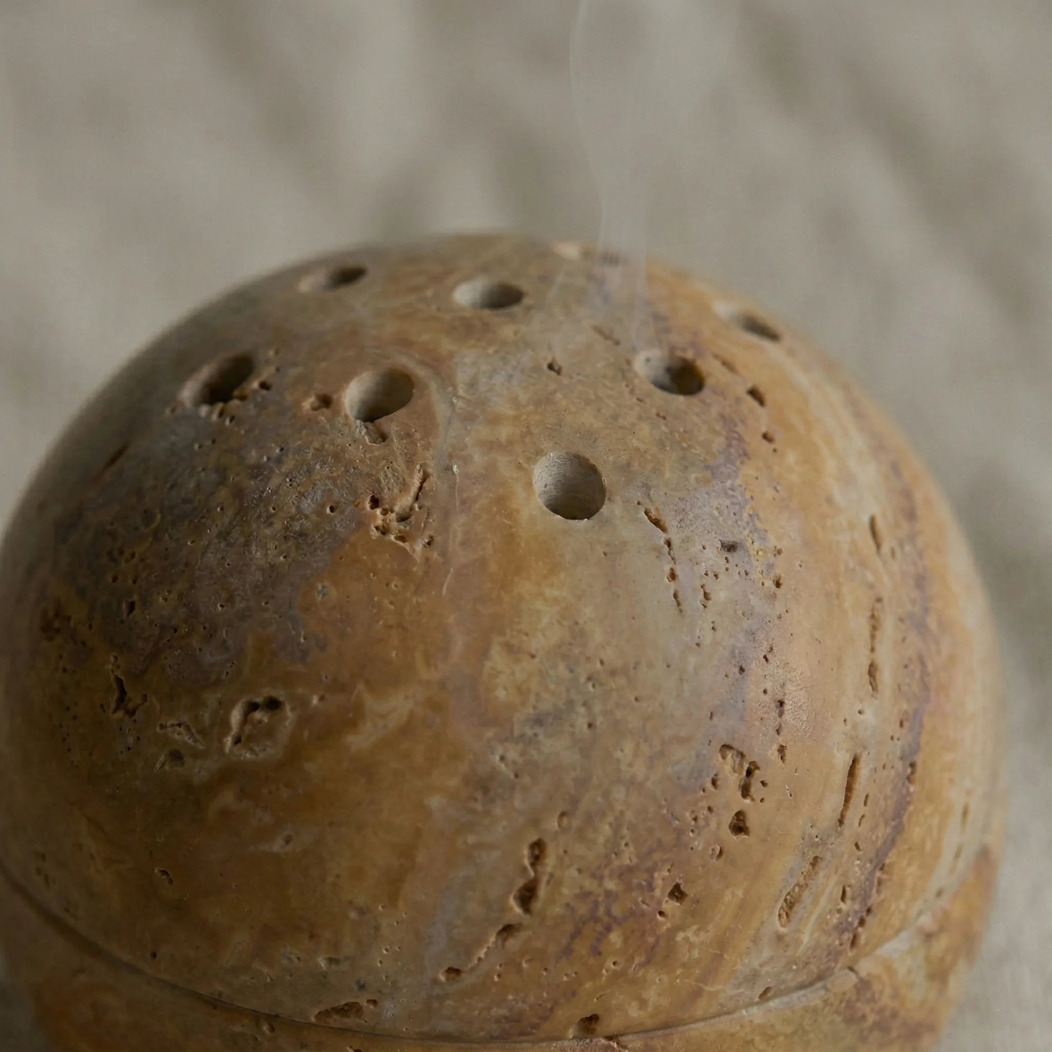 Macro zoom of Travertine Core Vessel showing natural pitted stone texture and earth tones