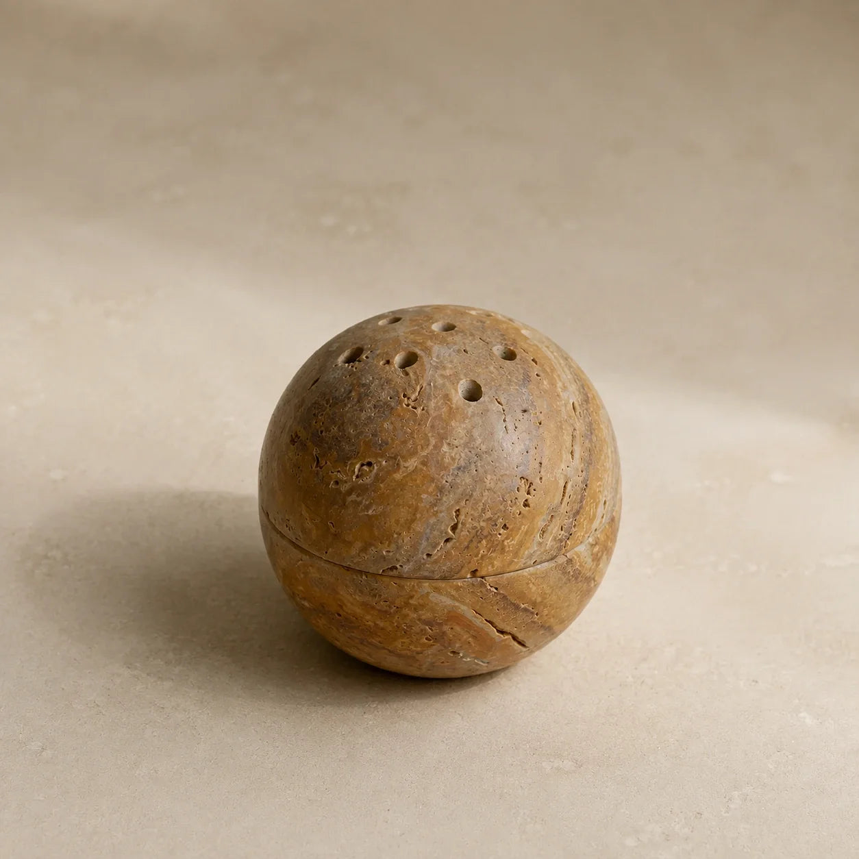 Natural travertine sphere incense vessel with perforated stone lid and unique stone texture