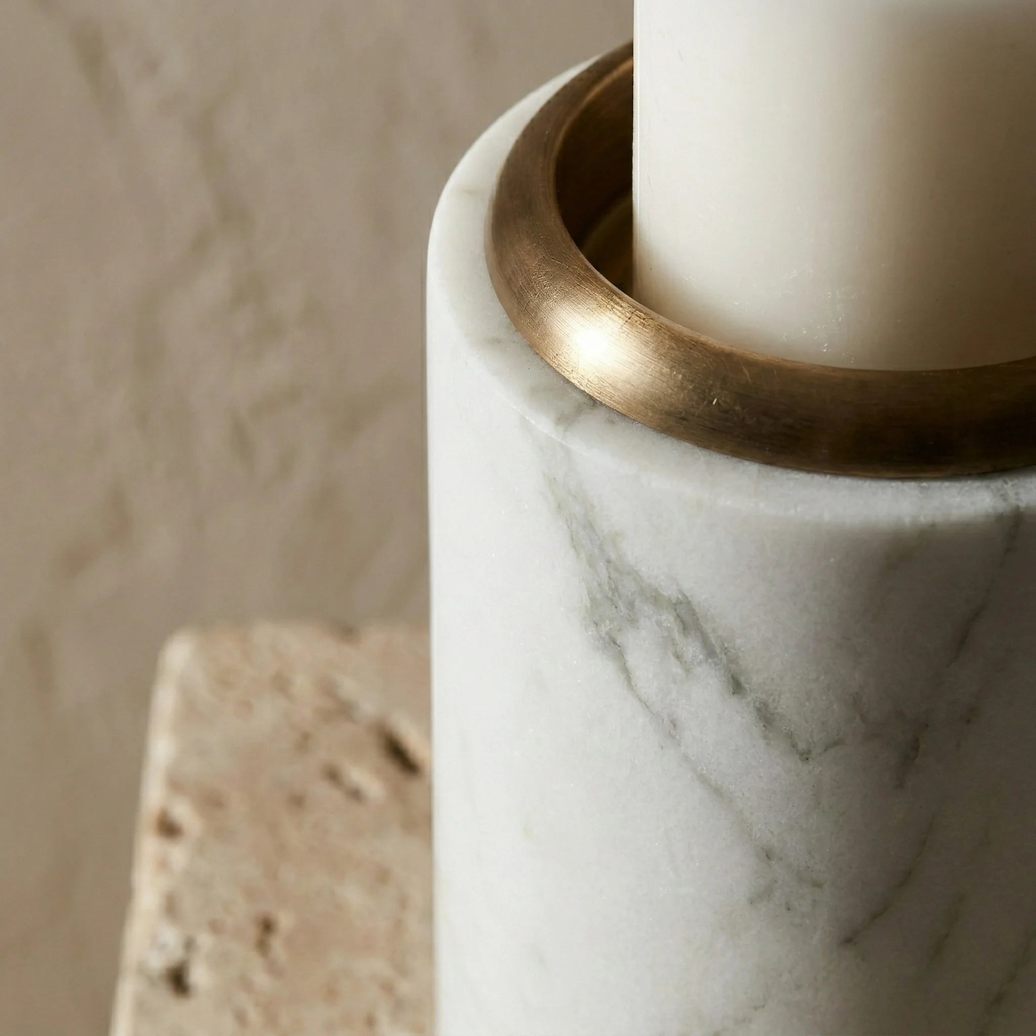 Close-up of Trio Monolith Pillars showing brass metal cup detail on white marble stone