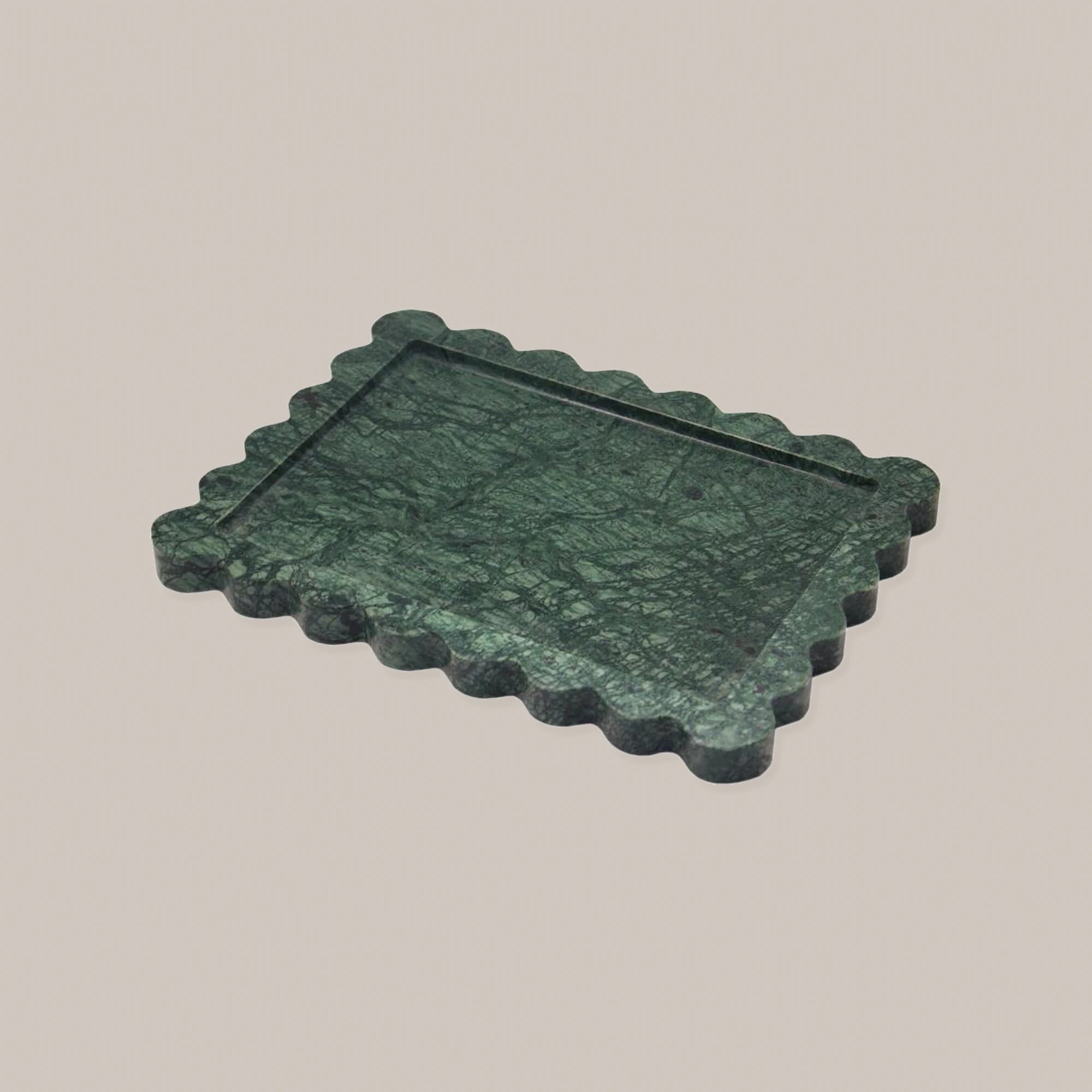 Dark green rectangular scalloped marble tray on a warm neutral background