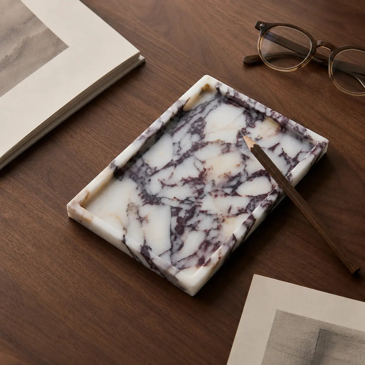 Calacatta Viola Marble Tray on a wooden desk with a pencil, books, and glasses — Verdora