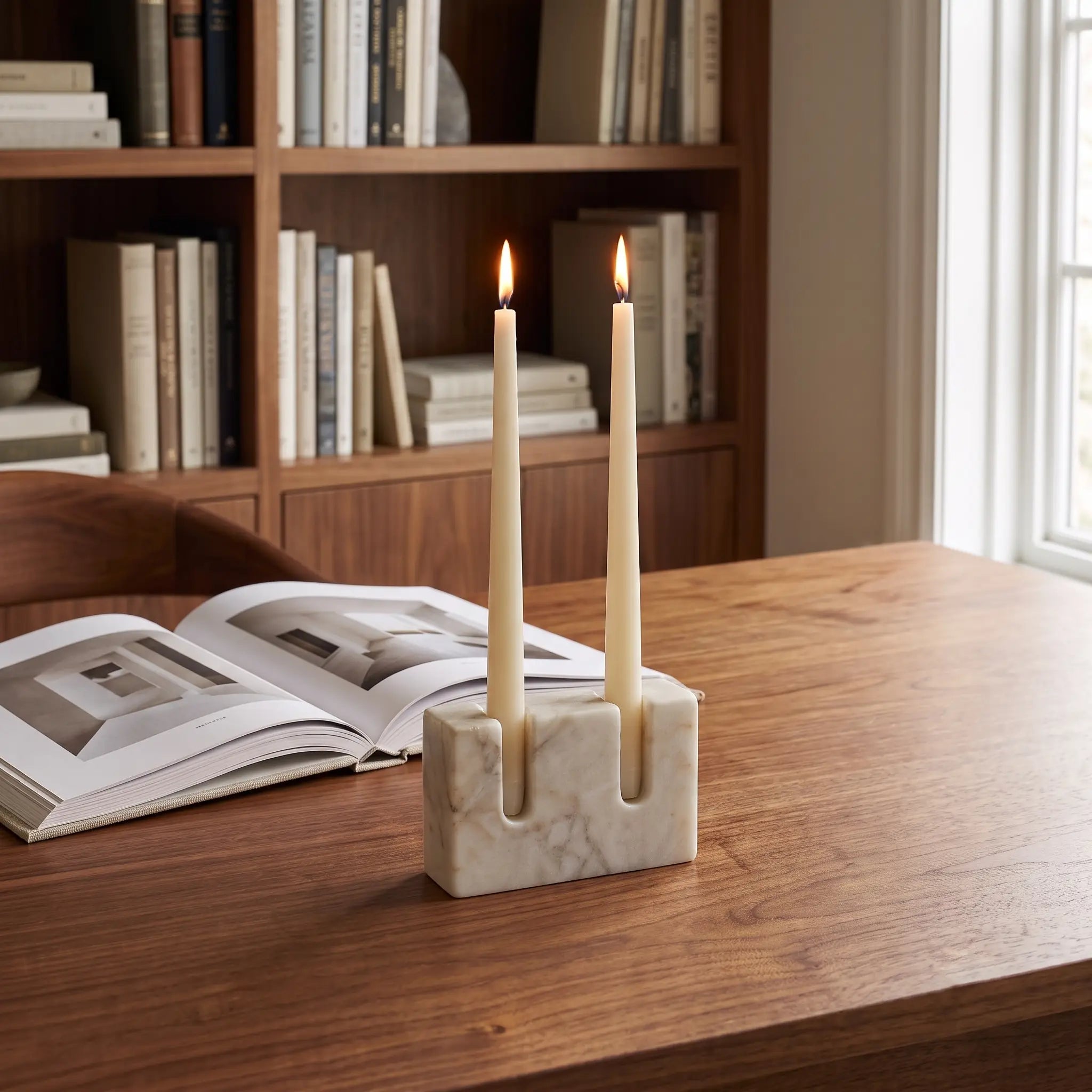 Double Slot Candle Holder in White Marble with lit taper candles on a wooden desk — Verdora