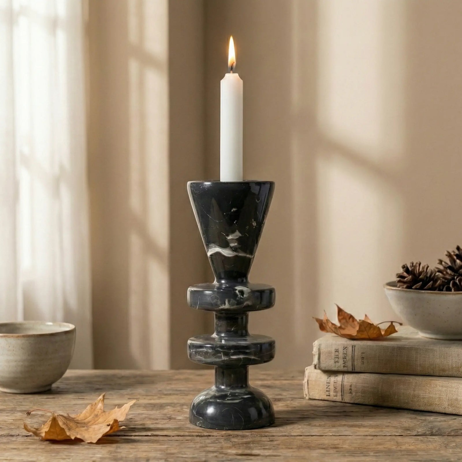 Black Marble Tower Holder with a burning taper candle in a cozy autumnal home setting