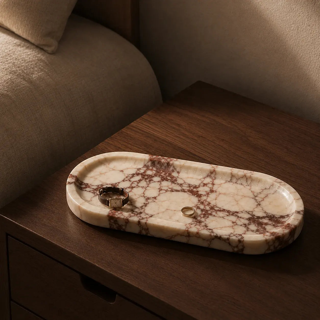 Calacatta Viola marble tray styled on a walnut bedside table with a watch and ring, showcasing natural red veining and a quiet luxury interior setting.