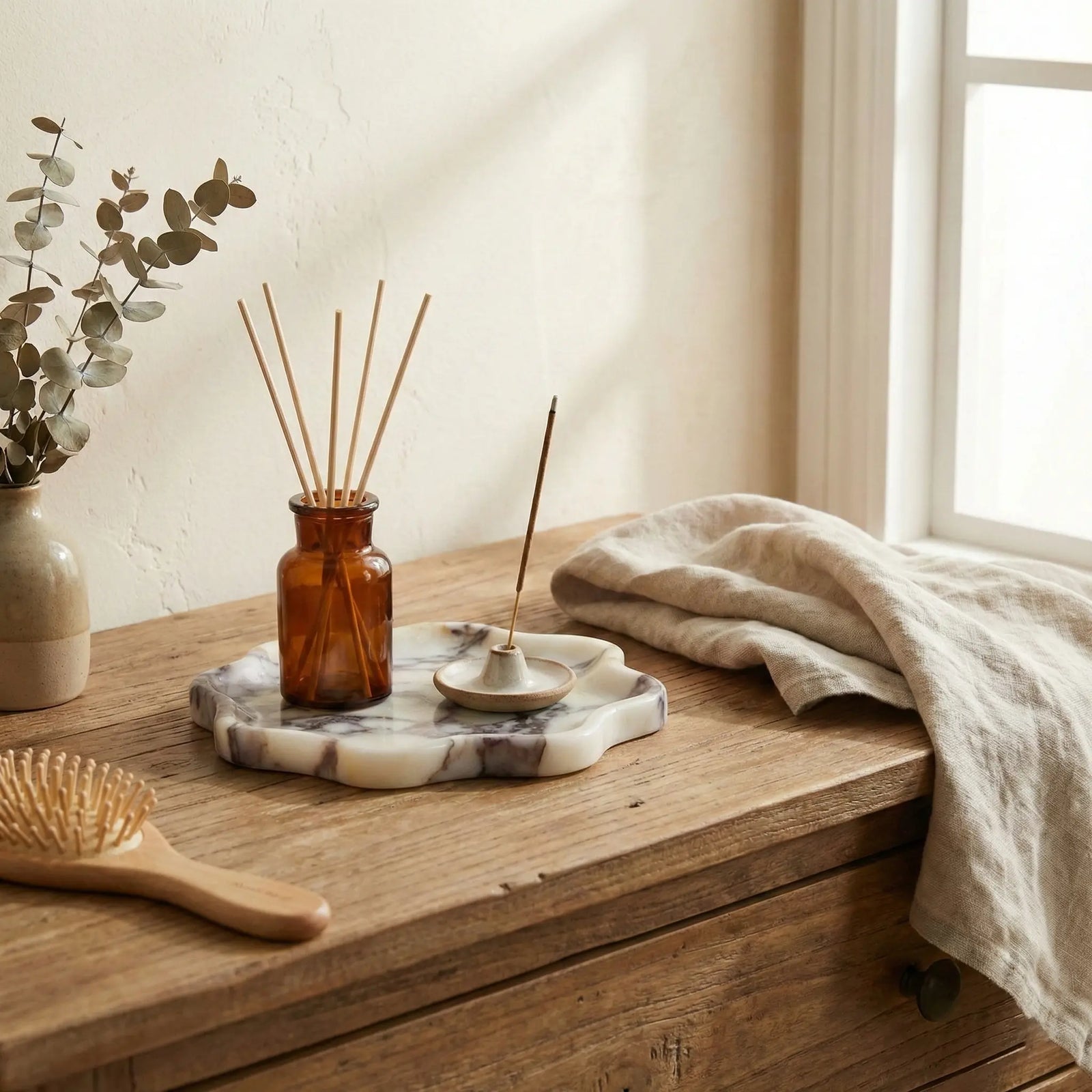Calacatta Viola marble stone tray with a diffuser and accessories in a bright lifestyle setting