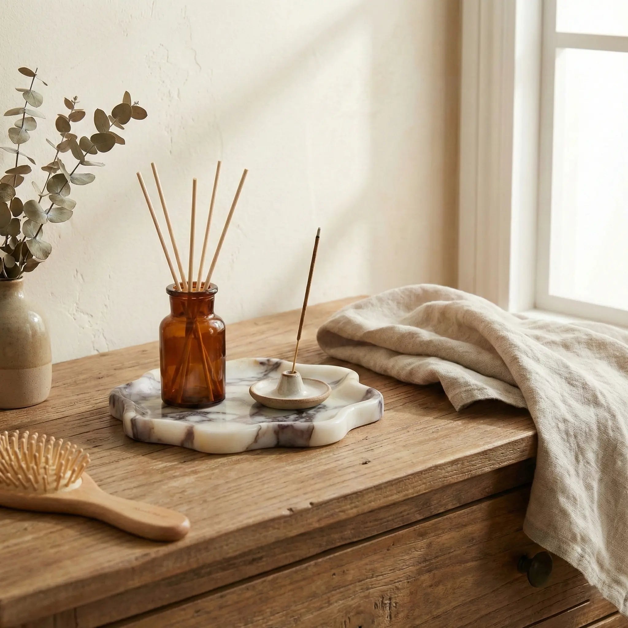 Calacatta Viola marble stone tray with a diffuser and accessories in a bright lifestyle setting