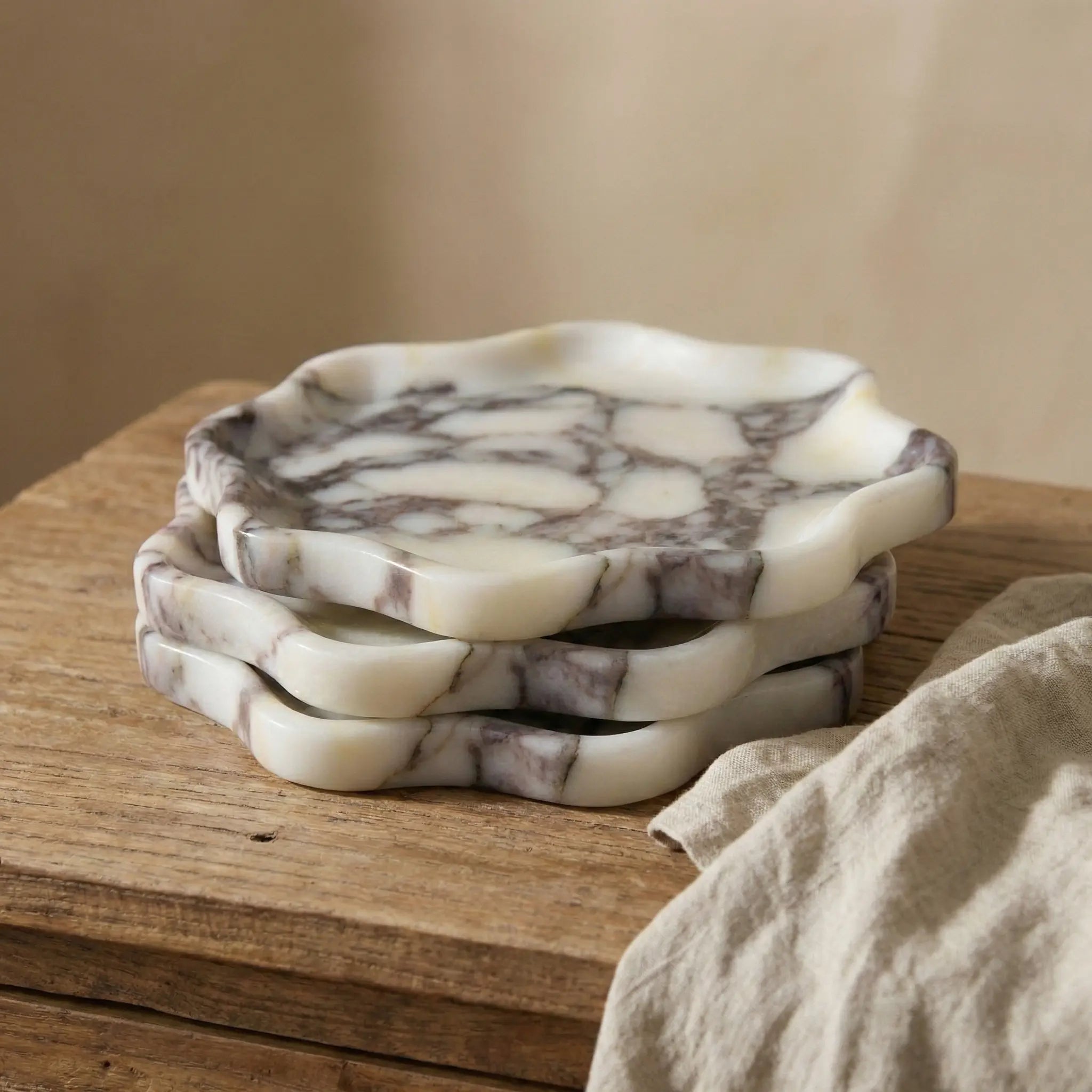Three Calacatta Viola marble trays stacked to highlight unique natural stone patterns and edges