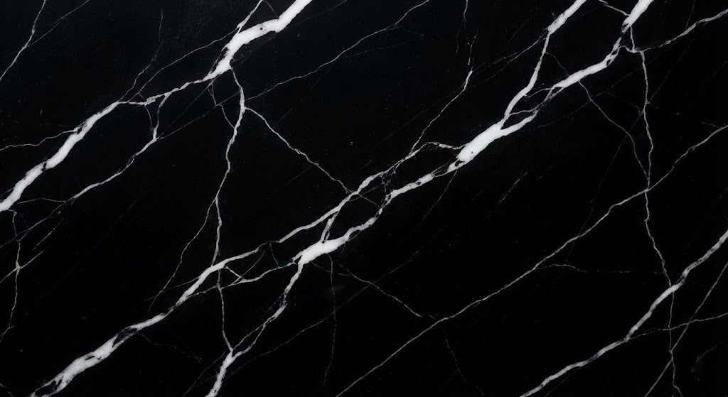 Luxury black marble stone texture with high-contrast sharp white mineral veins and deep dark tones.