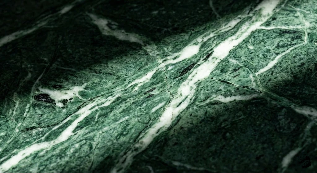 Detailed texture of natural forest green marble with rich white mineral veining and dark stone patterns.