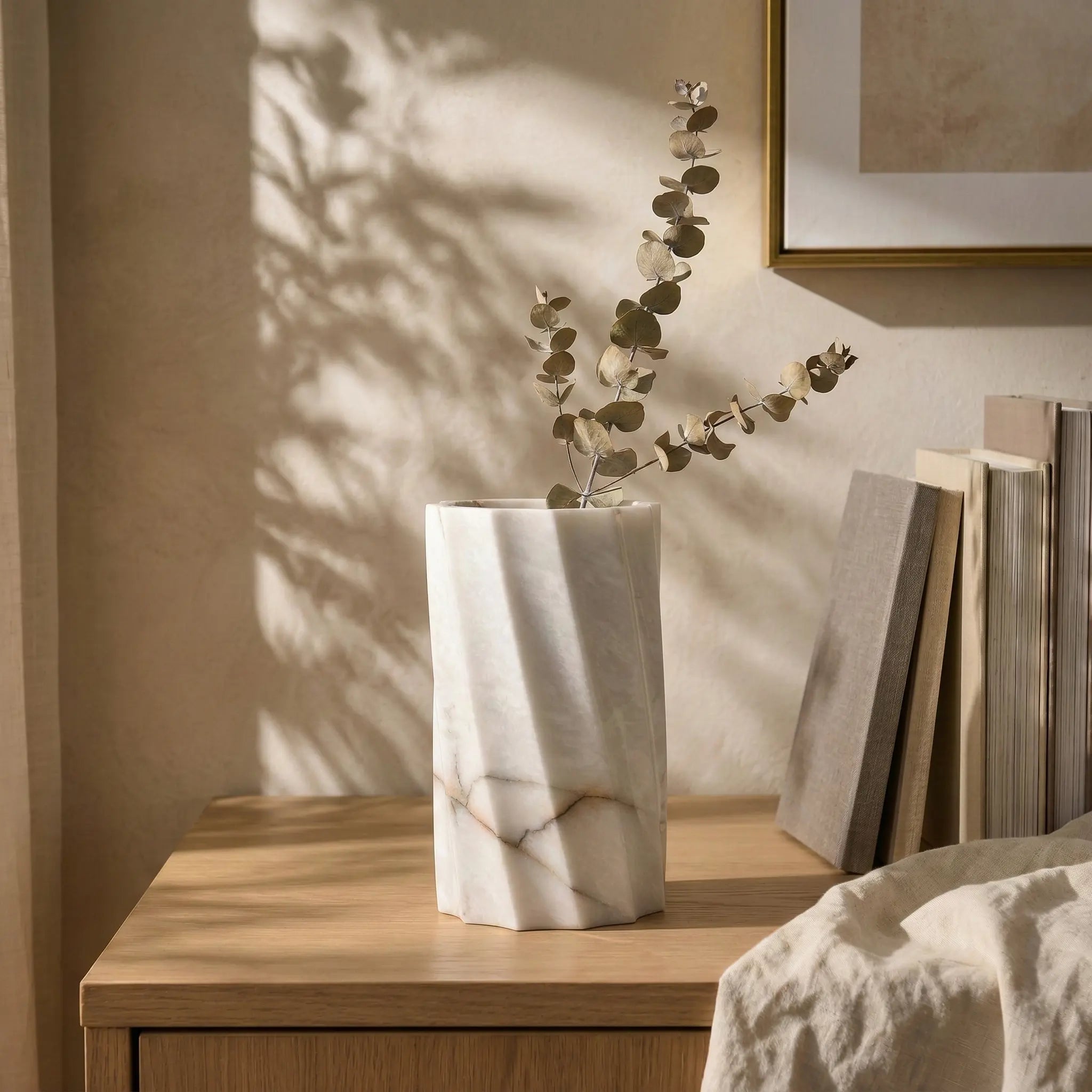 Cylindrical Monolith Vase used as a luxury floral decor piece on a wooden bedside table with soft sunlight.