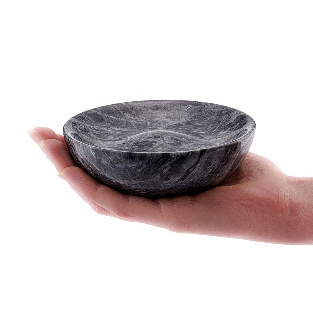 Hand holding the Marble Incense Bowl to show its deep bowl shape and handcrafted stone scale