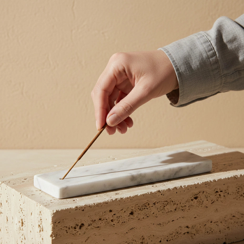 Hand placing an incense stick into the Marble Incense Tray white stone holder
