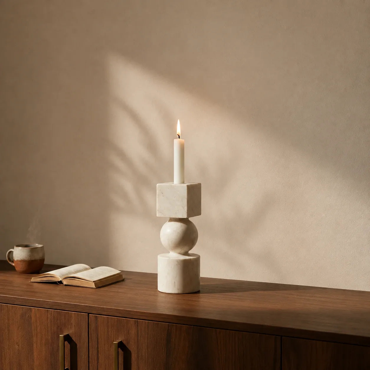 Sculptural natural stone candle holder on a walnut console table with soft afternoon light and minimalist interior styling.