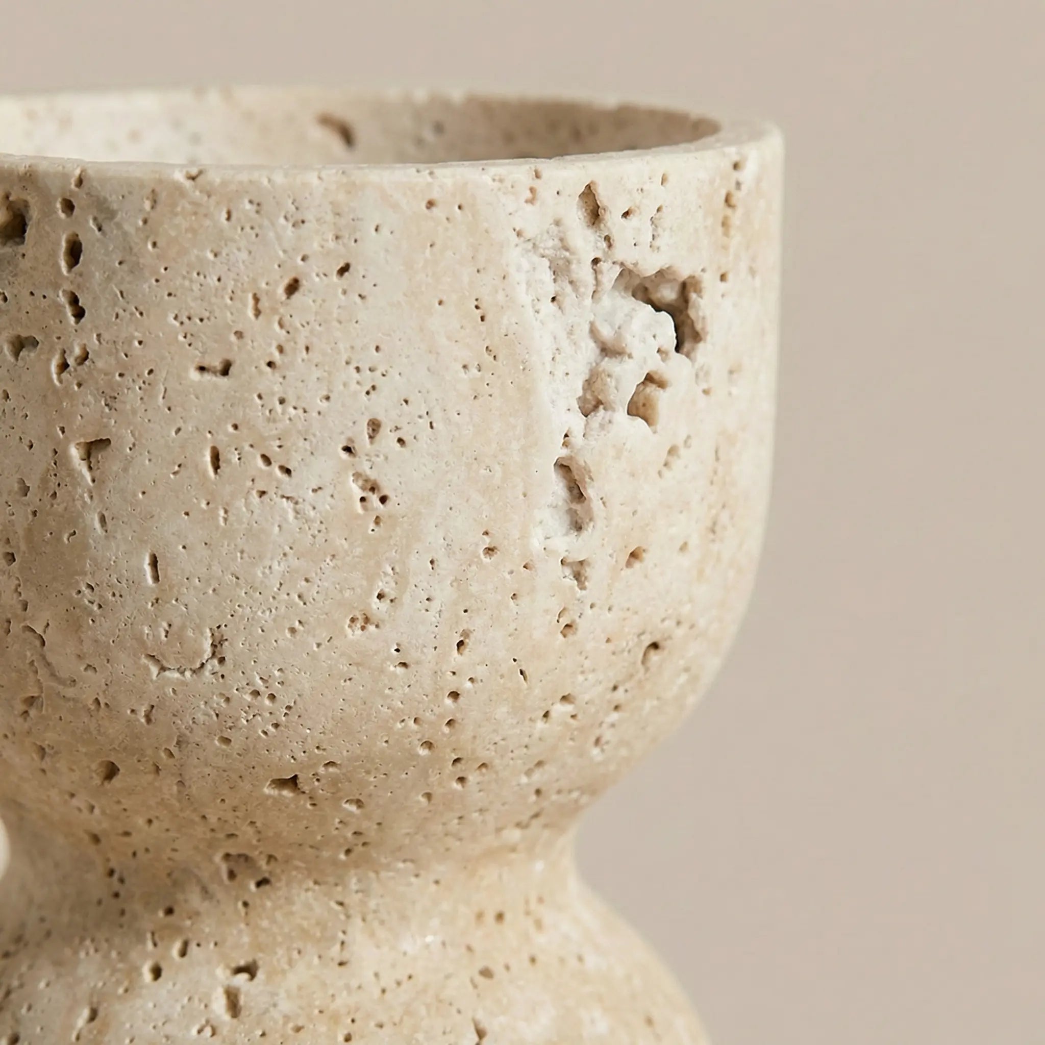 Detailed macro zoom of Travertine Hourglass Holder highlighting the raw pitted and porous stone texture.