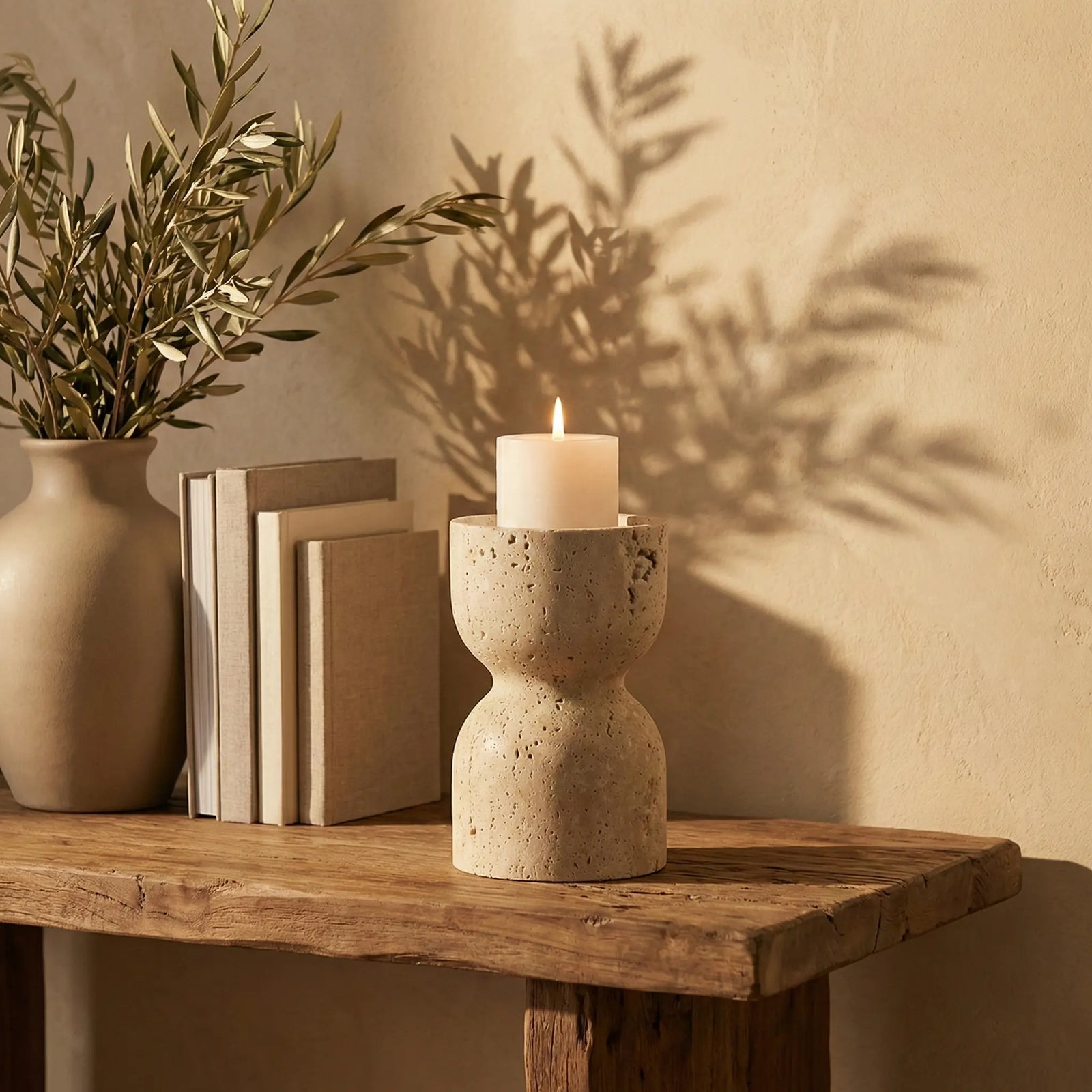 Travertine Hourglass Holder stone candle pedestal on a minimalist table in a cozy home decor setting.