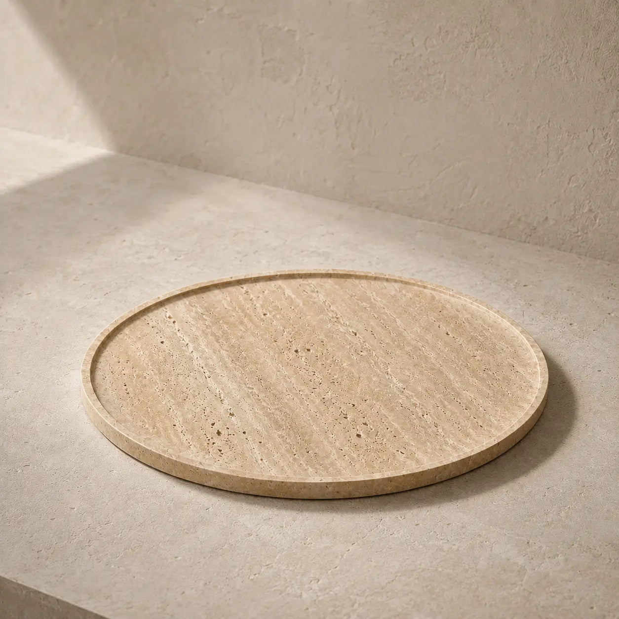 Large 30 cm round travertine tray with a slim rim and natural stone veining in a warm architectural setting.