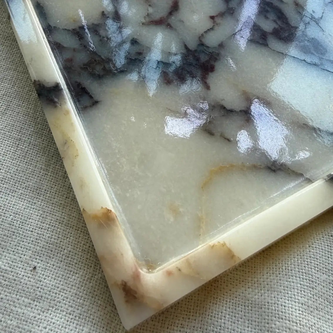 Side view of Calacatta Viola marble plateau tray with slim raised edge